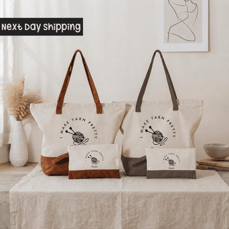 a set of two tote bags and a small bag, all with the text "I make yarn pretty" printed on them. The bags are placed on a table, and there is a vase and some books visible in the background.