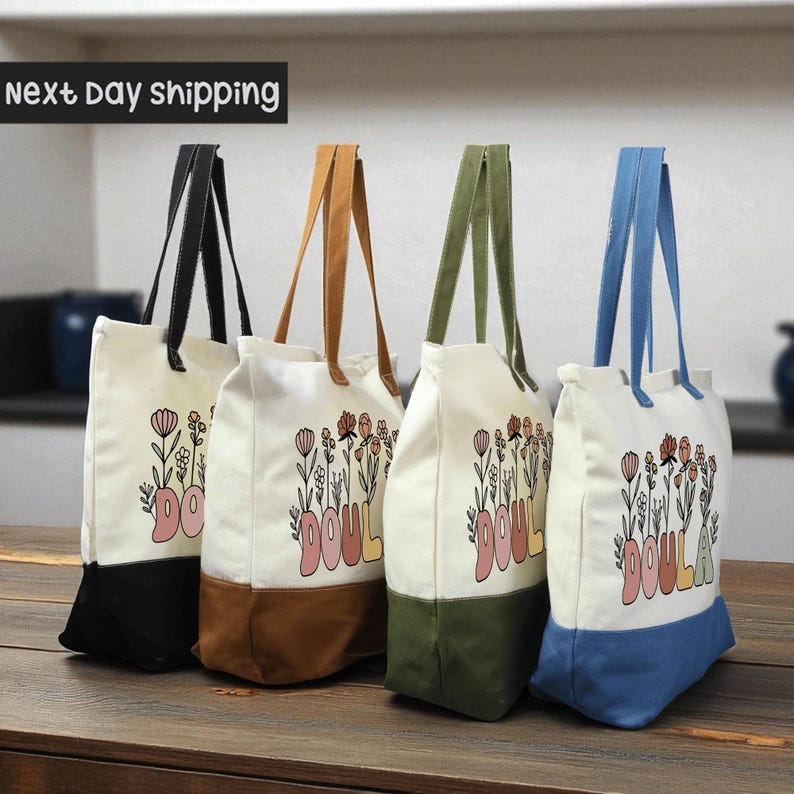 four colorful tote bags with the word "DOULA" printed on them, arranged on a wooden surface.