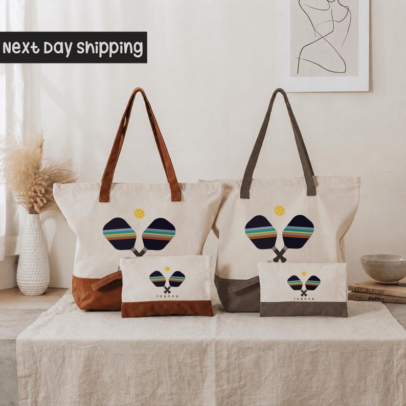 two tote bags with tennis racket designs, placed on a table with a vase and some books in the background.