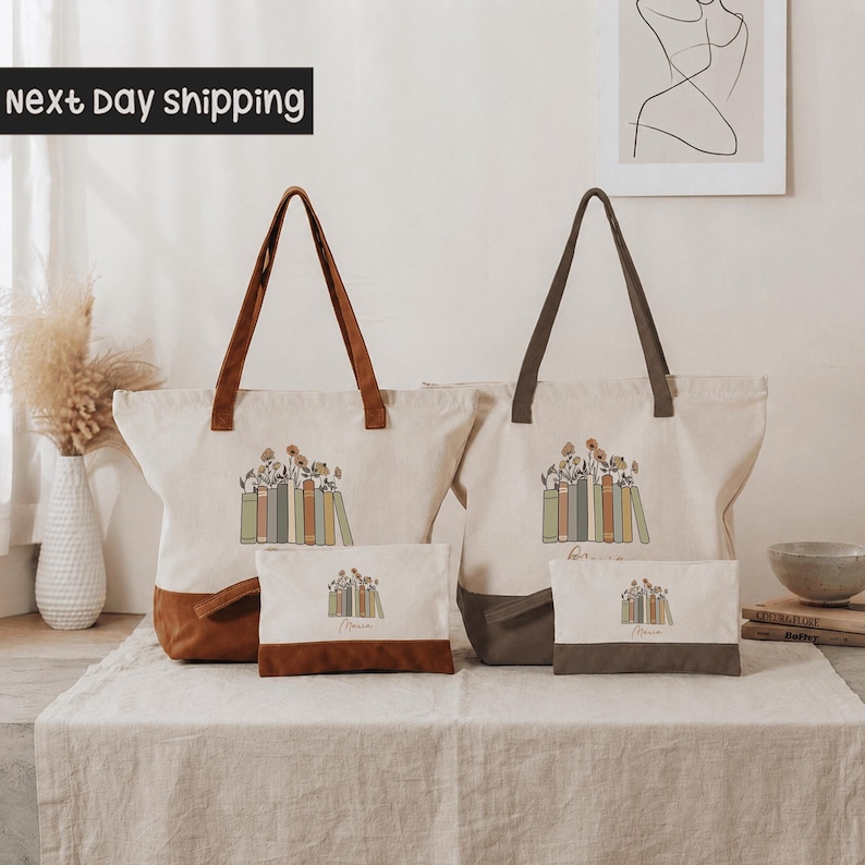 two tote bags with a floral design, placed on a table with a vase and some books.