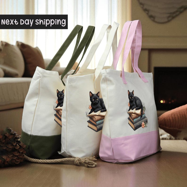 Three tote bags with cat illustrations on them, placed on a wooden surface.