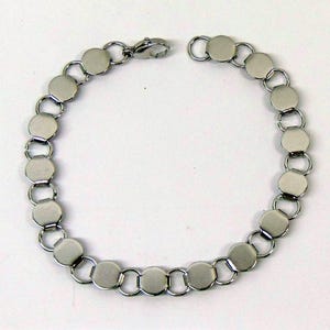 May include: A silver-toned bracelet featuring a series of connected, flat, circular links. The bracelet has a lobster clasp closure. The links are approximately 0.75 inches in diameter. The jewelry is displayed on a white background.