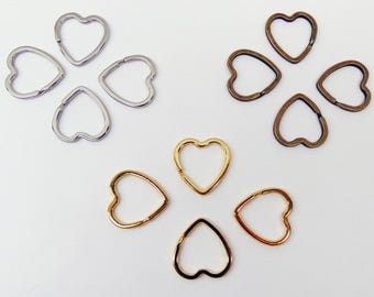 May include: An assortment of heart-shaped metal clasps in silver, gold, and bronze tones. The clasps are arranged in clusters of four and five, showcasing their different finishes and designs. Ideal for jewelry making.