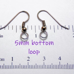 May include: Two silver-toned metal earring hooks with a coiled spring and a small bead, featuring a 5mm bottom loop. The hooks are positioned above a ruler showing measurements in inches, with text stating 5mm bottom loop.