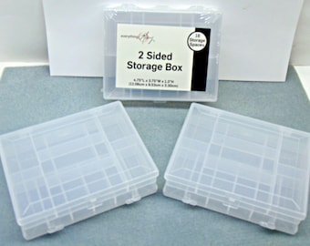 May include: Clear plastic 2-sided storage boxes. The boxes have multiple compartments for organizing small items. The label reads "2 Sided Storage Box" with dimensions of 12.06cm L x 9.53cm W x 3.30cm H. The boxes are designed to hold 16 storage spaces.