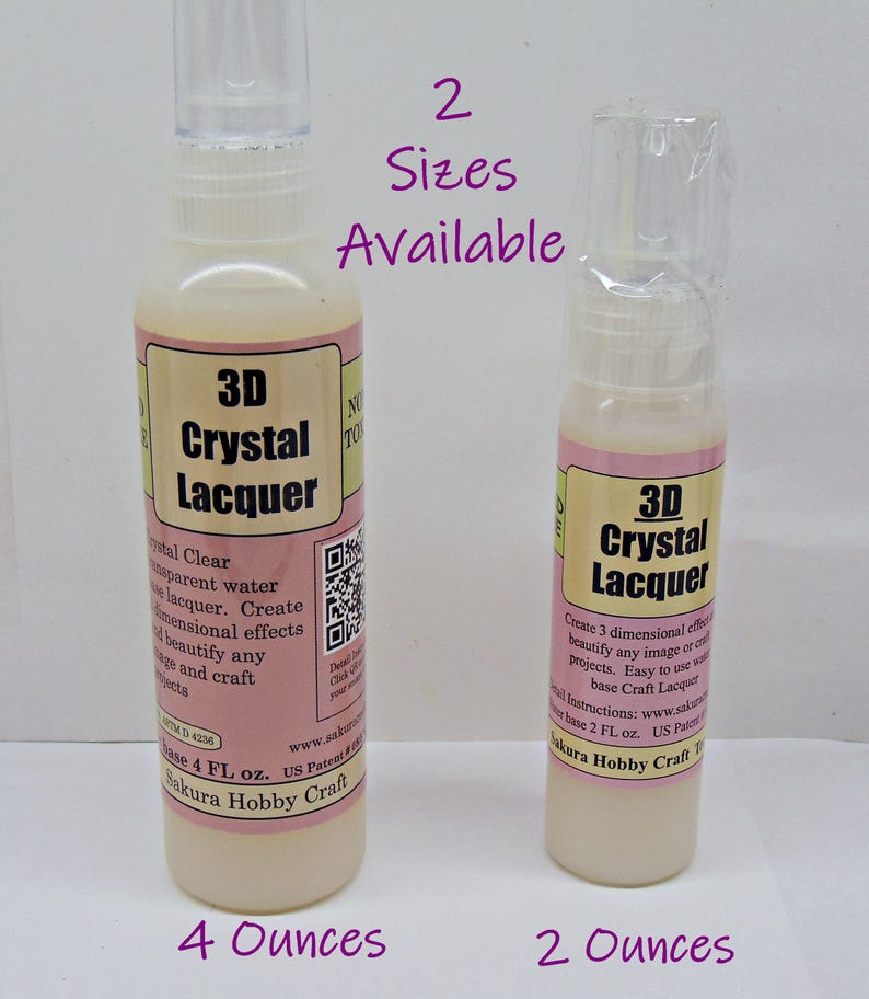May include: Two bottles of 3D Crystal Lacquer, one 4 ounces and the other 2 ounces. The bottles have a clear spray nozzle and a pink and cream label. The text on the label says "3D Crystal Lacquer" and "Sakura Hobby Craft".