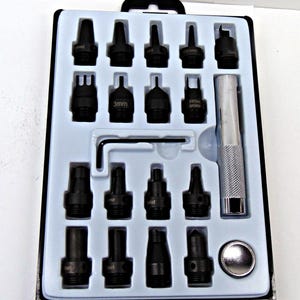 May include: A black leather punch set with various punch heads, a handle, and a small wrench. The set is in a black case with a white interior. The punch heads are different shapes and sizes.