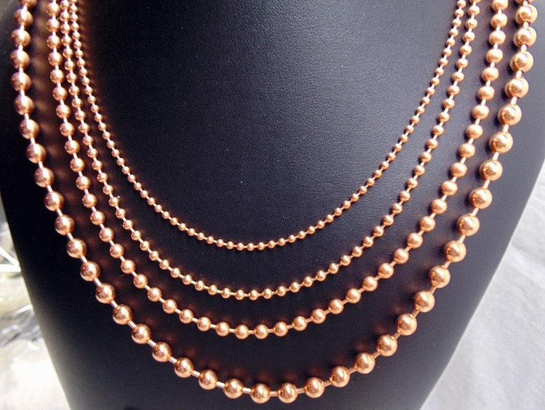 Juego de collar de 4 cadenas de bolas de cobre. Todas de 24" de largo. El tamaño de las bolas aumenta de 2,4 mm a 3,2 mm, a 4,5 mm y a 6,3 mm. Producto de EE. UU. 99,97 % puro. Sin níquel. imagen 1
