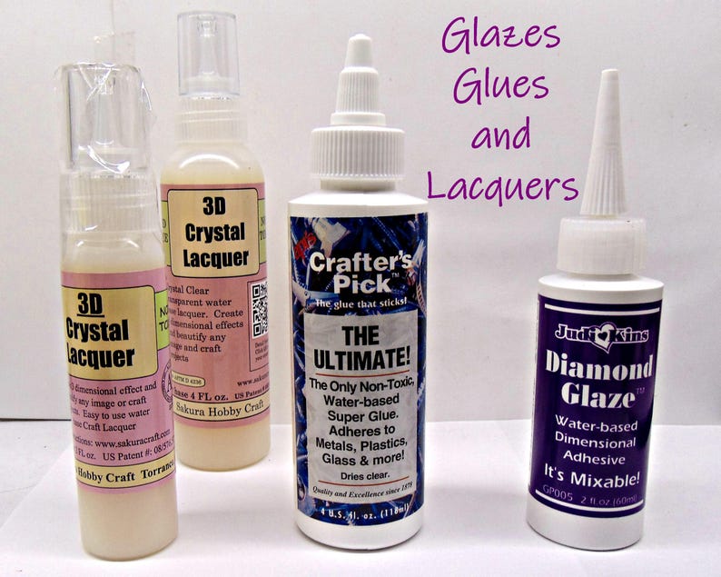 May include: Four bottles of craft supplies, including 3D Crystal Lacquer and Diamond Glaze. The bottles are white with colorful labels and white caps. The text "Glazes, Glues and Lacquers" is written in purple.
