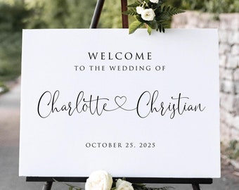May include: White welcome sign with black text on an easel. The sign reads "Welcome to the wedding of Charlotte & Christian October 25, 2025".