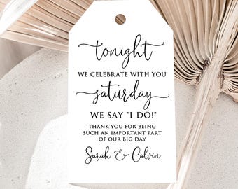 May include: White tag with the text "tonight, we celebrate with you Saturday, we say 'I do!'" and the names "Sarah & Calvin" in black script. The tag has a small hole at the top for hanging.
