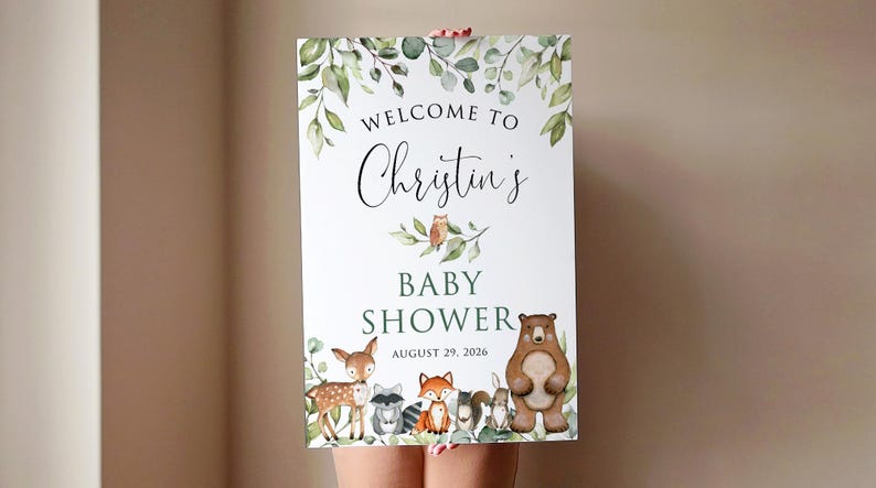 May include: Welcome to Christine's Baby Shower sign with a green leafy border and woodland animal illustrations including a deer, owl, bear, raccoon, fox, and squirrel. The date is August 29, 2026.