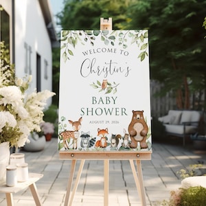 May include: Welcome to Christine's Baby Shower sign with a green leafy border and woodland animals including a deer, raccoon, fox, squirrel, rabbit, and bear. The date of the shower is August 29, 2026.