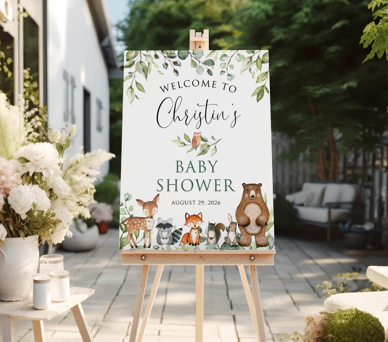 May include: Welcome to Christine's Baby Shower sign with a green leafy border and woodland animals including a deer, raccoon, fox, squirrel, rabbit, and bear. The date of the shower is August 29, 2026.