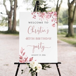 May include: Welcome to Christin's 40th Birthday party, 15 August 2026. A white sign with pink floral watercolour design and black calligraphy text.