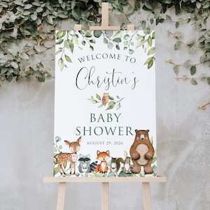 May include: Welcome to Christin's Baby Shower sign with a white background and green foliage. The sign features a brown bear, a fox, a deer, a raccoon, a squirrel, and a rabbit. The text on the sign reads "Welcome to Christin's Baby Shower August 29, 2026".