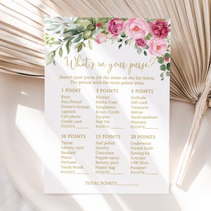 May include: A white card with the text "What's in your purse?" and a list of items with point values. The card is decorated with pink roses and green foliage. The game is for a bridal shower.