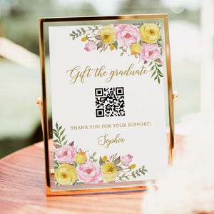 May include: A gold-framed sign featuring the words "Gift the graduate" and a QR code. The sign is adorned with pink and yellow watercolour flowers. The text "THANK YOU FOR YOUR SUPPORT!" and the name "Sophia" are also included.