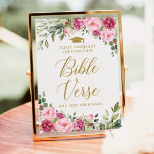 May include: A gold framed sign with the text "Bible Verse" in elegant script, surrounded by watercolor floral arrangements in pink and green. The sign also includes the text "Please Highlight Your Favorite" and "And Sign Your Name".