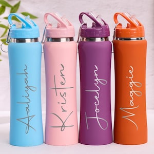 May include: Four colorful water bottles with names: Aaliyah, Kristen, Jocelyn, and Maggie. Each bottle is a different color: blue, pink, purple, and orange. They have a silver cap and a flip-top lid. The bottles are approximately 10 inches tall.