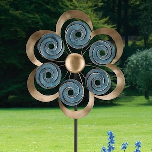 May include: A metal garden spinner in the shape of a flower with six blue and gold swirling circles. The spinner is mounted on a black metal stake.