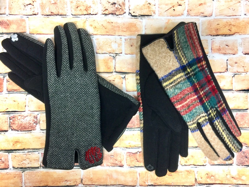 May include: Two pairs of gloves, one with a black and white herringbone pattern and a red monogram, and the other with a plaid pattern in red, green, blue, and yellow.