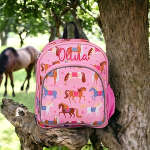 May include: Pink horse-themed backpack with a mesh side pocket. The backpack has the name "Olivia" embroidered on the front.