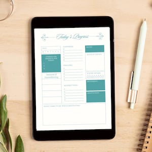 May include: A digital tablet displaying a daily planner page with the title "Today's Progress." The planner includes sections for date, mood, gratitude, water intake, and meditation. A white pen and glasses are on the wooden surface.
