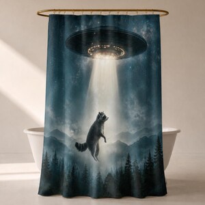 May include: A shower curtain featuring a dark blue night sky with a glowing UFO hovering above a forest of pine trees and mountains. A raccoon is depicted floating in the center, caught in a bright beam of light emanating from the spacecraft.