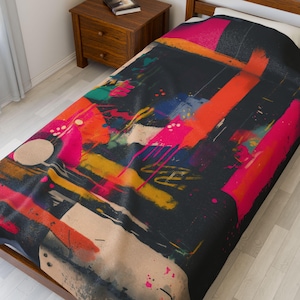 May include: A twin-sized bedspread with an abstract design. The bedspread features a black background with bold strokes of orange, pink, yellow, blue, and white paint. The design has a modern, artistic feel.