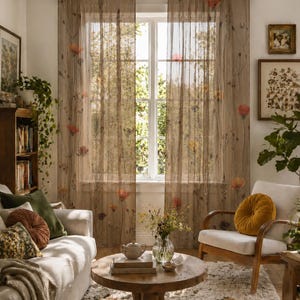 May include: Two sheer, light brown curtains hang from a dark rod over a window. The fabric features a delicate, scattered botanical print of thin stems and small, muted red and orange flowers, allowing soft natural light to filter through.