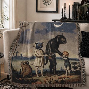 May include: A woven throw blanket featuring a surreal illustration of anthropomorphic creatures under a night sky with a crescent moon. The artwork depicts a black cat-like figure interacting with children, with a fringe border.