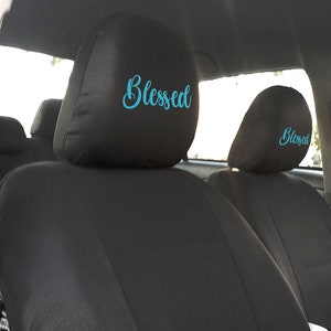 Puede incluir: Dos reposacabezas de asiento de coche negros con la palabra "Blessed" bordada en azul turquesa.