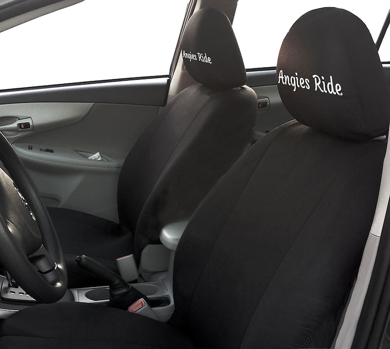 Puede incluir: Fundas para asientos de coche negras con texto bordado en blanco que dice "Angies Ride" en los reposacabezas.