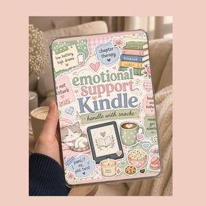 May include: A clear Kindle case with a whimsical design. The case features the words "Emotional Support Kindle" and "handle with snacks." Decorative elements include a cat, books, a coffee cup, and the text "low battery, high drama."