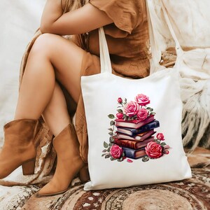 May include: White canvas tote bag featuring a design of a stack of books topped with pink roses. The bag has long straps.