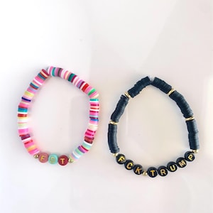 Puede incluir: Dos pulseras de cuentas con cuentas de letras que deletrean "FDT" y "FCK TRUMP". La pulsera "FDT" está hecha con cuentas de colores y la pulsera "FCK TRUMP" está hecha con cuentas negras.