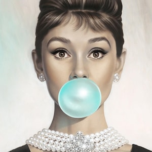 May include: A woman with a classic updo and pearl necklace blows a large blue bubble of bubble gum.