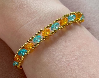 Pulsera de cuentas naranjas, azules y doradas inspirada en una corista