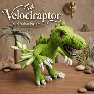 May include: A green crocheted dinosaur toy with white claws and a textured surface. The text "Velociraptor Crochet Pattern" is displayed in a decorative font above the figure. The dinosaur has a wide open mouth with visible teeth.