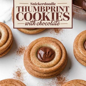 K&ouml;nnte beinhalten: Nahaufnahme von sechs Snickerdoodle-Daumenabdruck-Kekse mit Schokoladenf&uuml;llung. Die Kekse sind auf einer wei&szlig;en Marmorfl&auml;che mit Zimt bestreut angeordnet. Der Text "Snickerdoodle Thumbprint Cookies with chocolate" ist auf einem braunen Rechteck dargestellt.