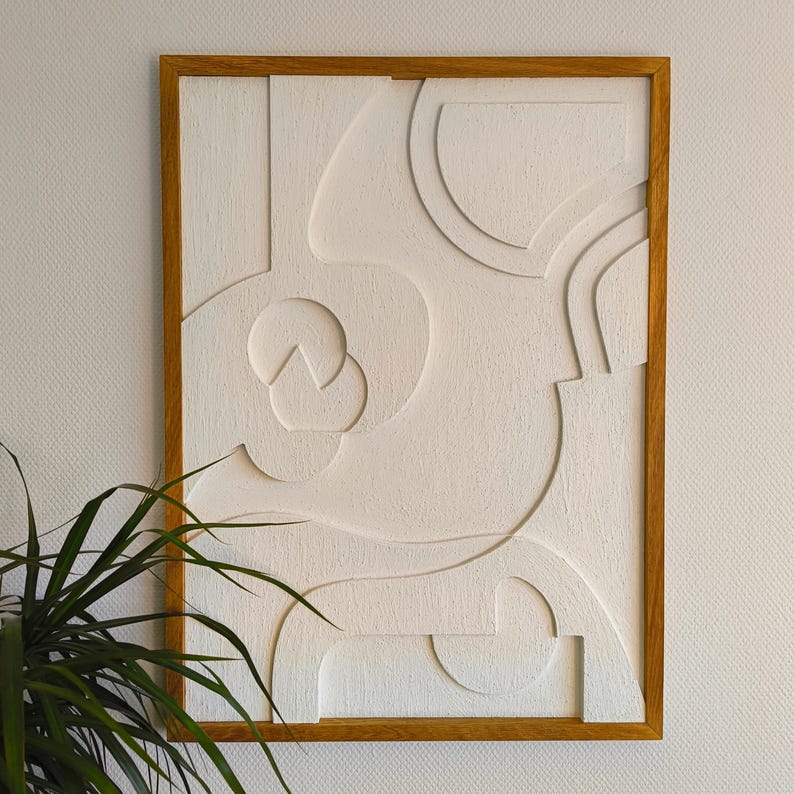 Modernes 3D Wandrelief im Format 76 x 56 x 2 cm mit geöltem Rahmen aus massivem Eichenholz, gefertigt aus präzise CNC-gefrästem MDF mit strukturierter Oberfläche in Naturweiß. Das abstrakte Wandbild kombiniert minimalistisches Design mit handwerklicher Qualität und eignet sich perfekt als stilvolle Wanddeko im Wohnzimmer, Büro oder Flur. Japandi-Stil, natürliche Materialien und ruhige Ästhetik für moderne Wohnräume.