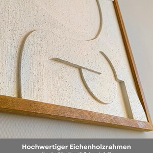 Detailaufnahme des hochwertigen Eichenholzrahmens eines abstrakten 3D Wandreliefs im Format 76 x 56 x 2 cm. Der massive Rahmen wurde von Hand mit natürlichem Leinöl geölt und bringt die warme Holzmaserung perfekt zur Geltung. Das Wandbild besteht aus CNC-gefrästem MDF mit strukturierter Oberfläche in Cremeweiß. Ideal als Wanddeko für Wohnzimmer, Büro oder Flur im Japandi- oder minimalistischen Stil – handgefertigt mit Liebe zum Detail.