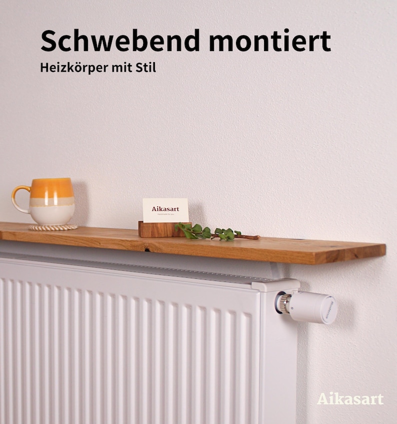 Massives Eichenholzbrett als Heizkörperablage, schwebend auf einem weißen Heizkörper montiert. Oben stehen eine Pflanze, eine Kerze und ein Buch. Die natürliche Maserung und das geölte Finish machen die Ablage zu einem stilvollen Deko-Element im Wohnraum.