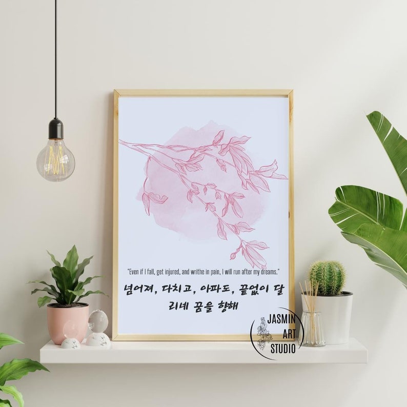 Puede incluir: Una impresi&oacute;n art&iacute;stica enmarcada con un dise&ntilde;o floral rosa claro y texto en ingl&eacute;s y coreano. La obra de arte est&aacute; sobre un fondo azul claro. La impresi&oacute;n se exhibe en un estante blanco con plantas y objetos decorativos.