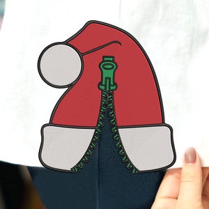May include: A red and white Santa hat with a green zipper down the center. The zipper is open and the hat is on a white background.