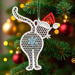 May include: White cat-shaped Christmas ornament with a Santa hat. The ornament has a snowflake design and a honeycomb pattern. It is hanging on a Christmas tree with red and gold ornaments.