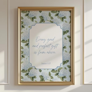 May include: A framed print with a gold-colored frame. The print features a light blue floral pattern with white hydrangea flowers. The center has a white background with the text "Every good and perfect gift is from above. James 1:17" in blue script.
