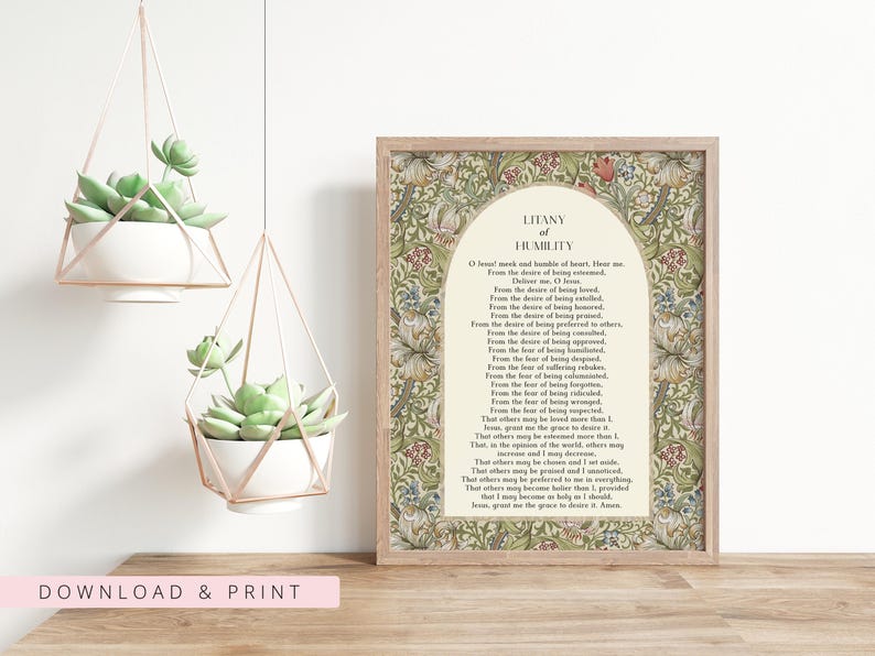 May include: A framed print featuring the Litany of Humility text centred within an arch, surrounded by a detailed floral pattern in shades of green, red, and tan. The print is displayed next to two white succulent planters in geometric frames.