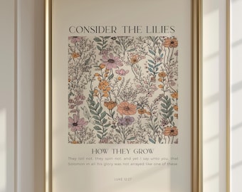 May include: A framed art print with a floral design in shades of pink, orange, and green. The text "CONSIDER THE LILIES" is at the top, with "HOW THEY GROW" below the floral pattern. The bottom text is a Bible verse from Luke 12:27.